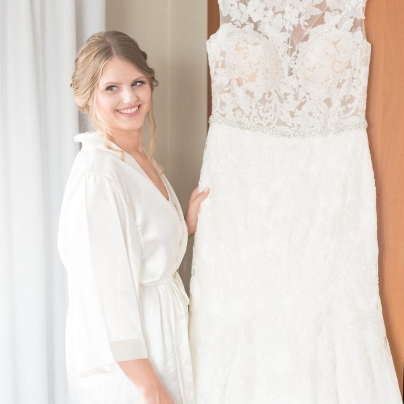 Bride with hanging wedding dress before her wedding by Indianapolis wedding photographer Victoria Rayburn Photography