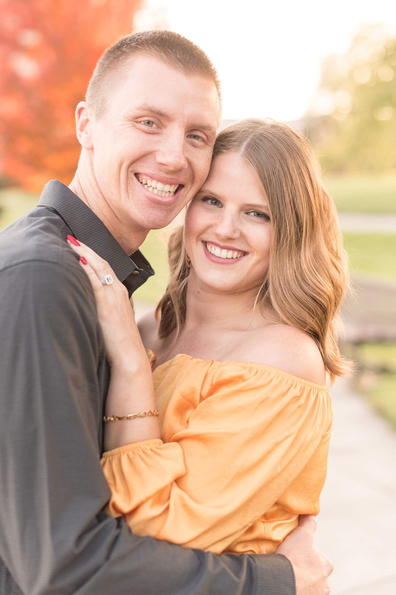 Couple hug on walkway during fall engagement photos by Indianapolis wedding photographer Victoria Rayburn Photography