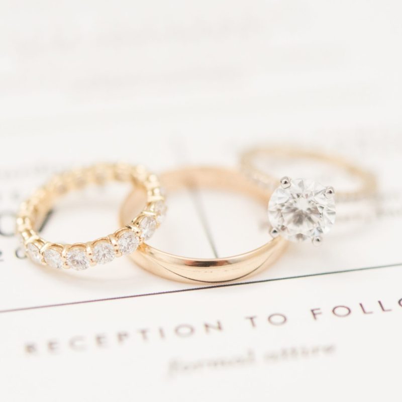Close up of gold wedding rings on invitations by Indianapolis wedding photographer Victoria Rayburn Photography
