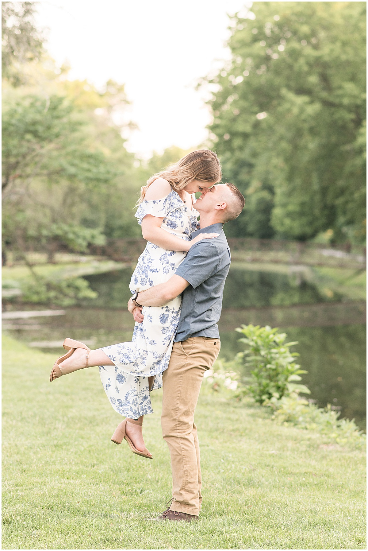 Man lifts his fiancee next to bridge by Indianapolis wedding photographer Victoria Rayburn Photography