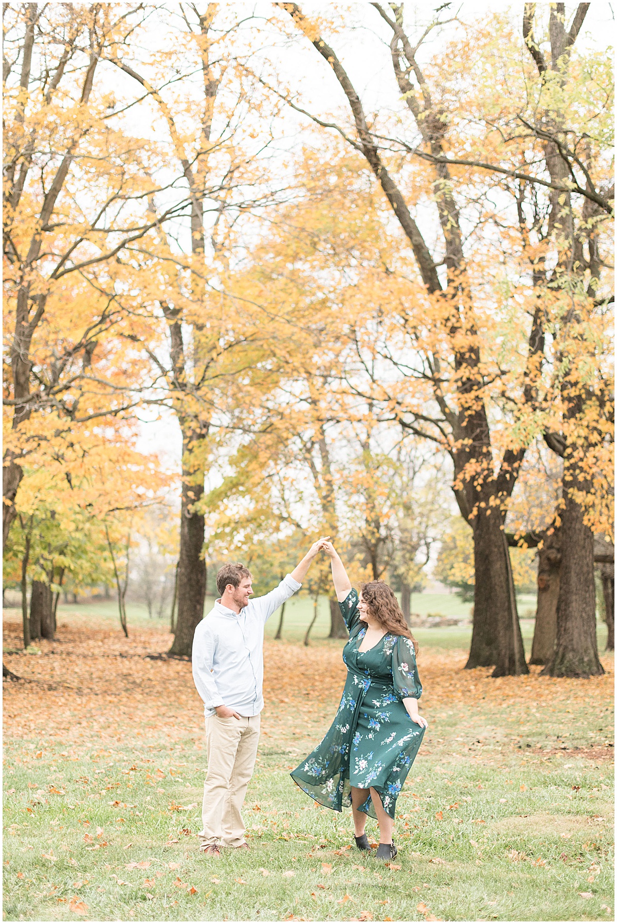 Couple dancing in fall leaves during engagement session by Indianapolis wedding photographer Victoria Rayburn Photography