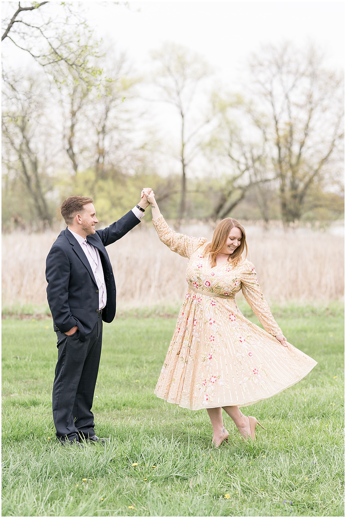Couple dancing in grass field during engagement session by Indianapolis wedding photographer Victoria Rayburn Photography