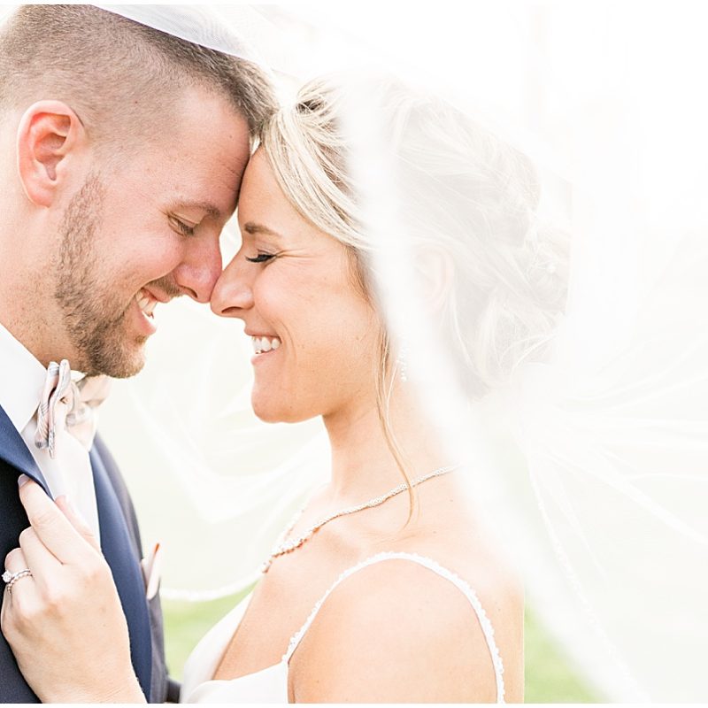 Bride and groom laugh under veil during wedding photos by Indianapolis wedding photographer Victoria Rayburn Photography