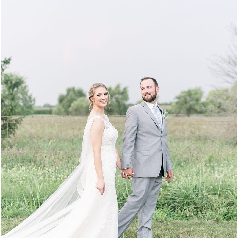 Bride and groom walk through field during sunset photos by Indianapolis wedding photographer Victoria Rayburn Photography