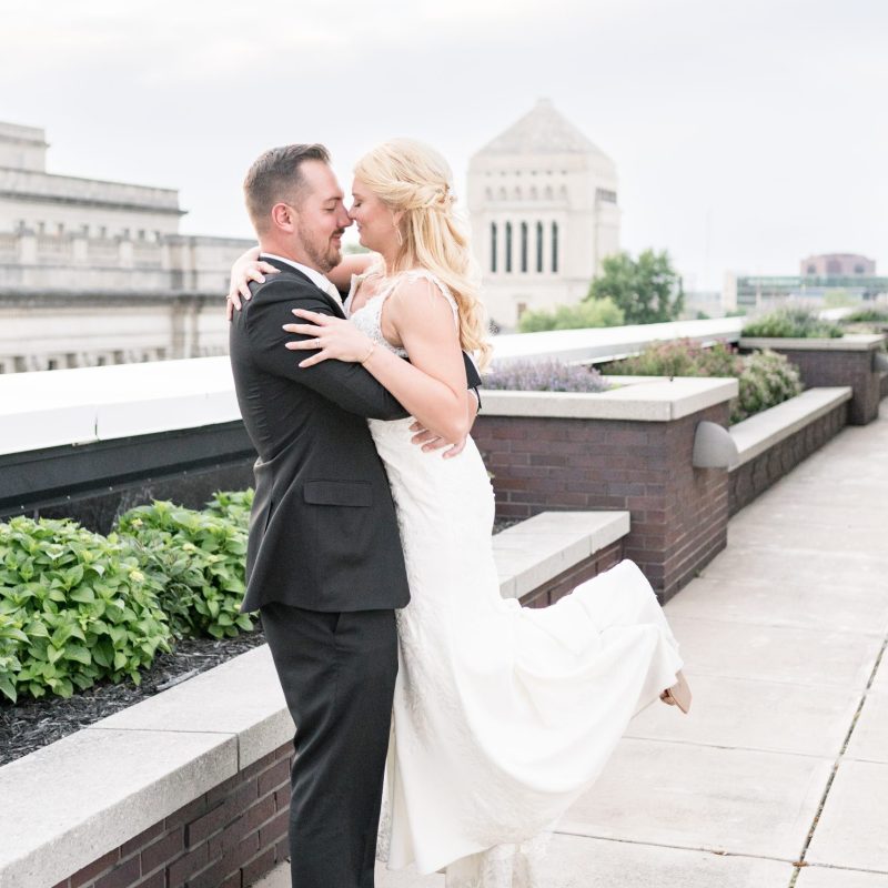 Groom lifts bride on rooftop after downtown wedding by Indianapolis wedding photographer Victoria Rayburn Photography
