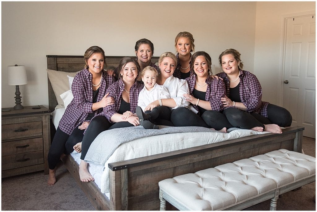Bride and bridesmaids on bed before wedding at Sacred Heart Catholic Church in Fowler, Indiana