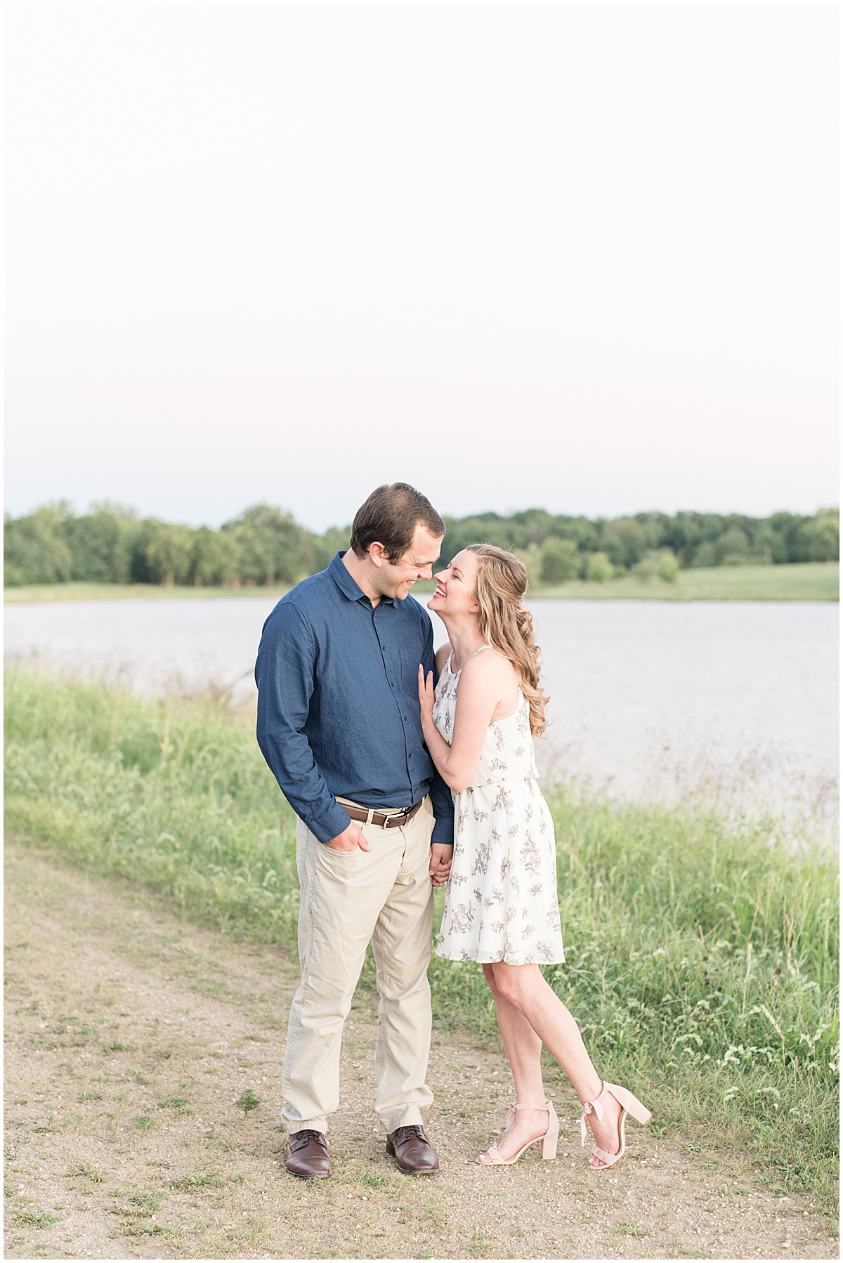 Holding hands next to water during Lakefront engagement photos in Lafayette, Indiana