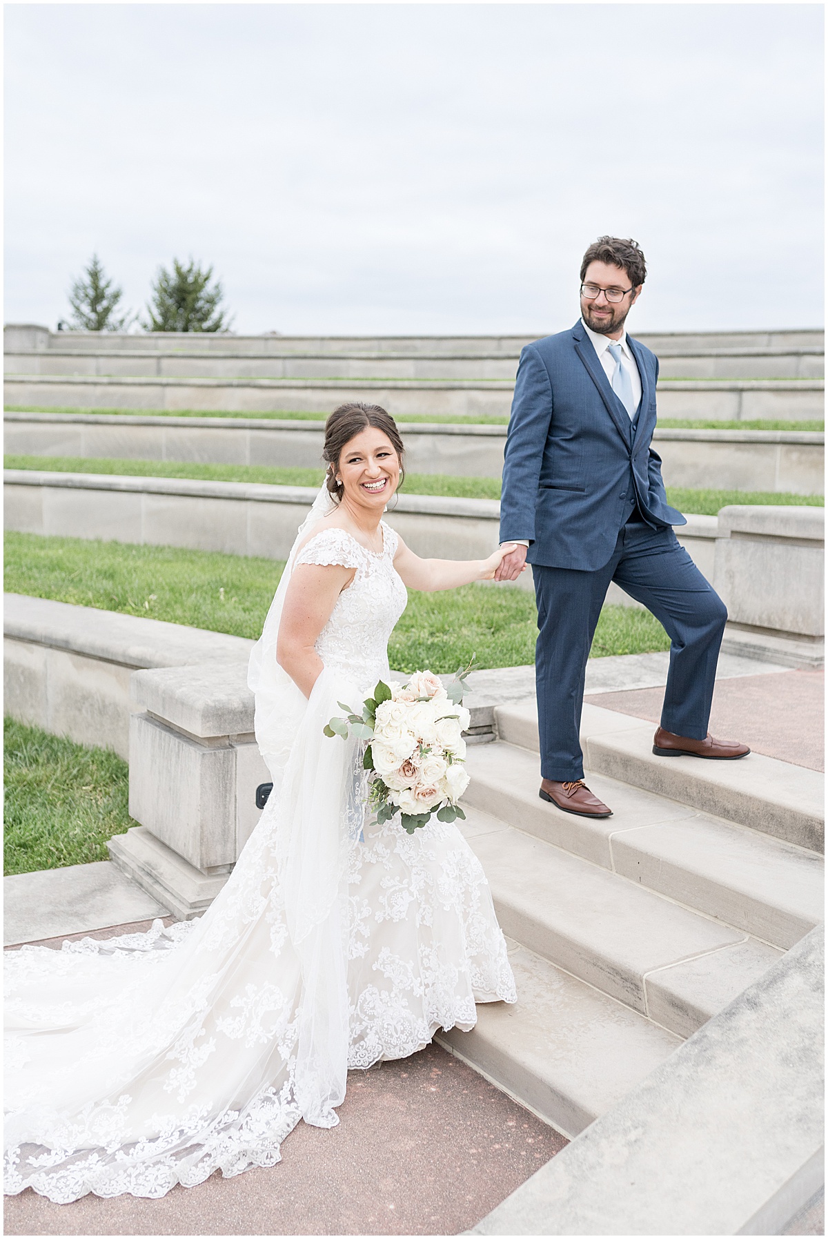 Bride and groom walk on steps during photos at Coxhall Gardens in Carmel, Indiana