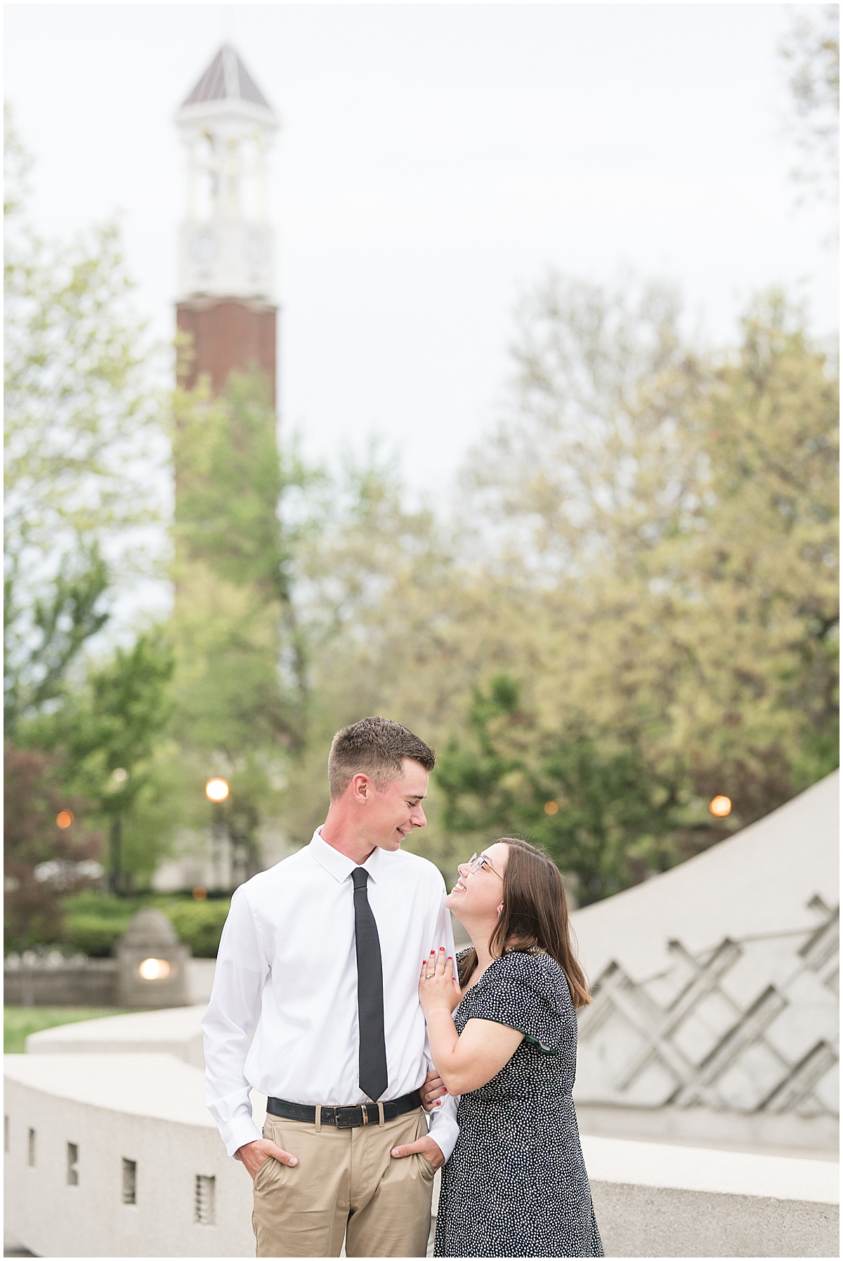 Couple admire each other during engagement and graduation photos by Purdue's Belltower