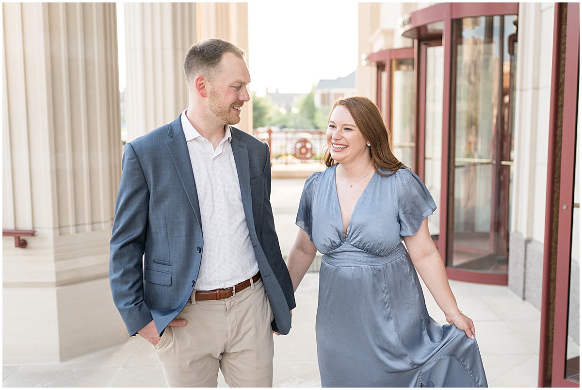 Couple walk at entrance during engagement photos at The Palladium in Carmel, Indiana