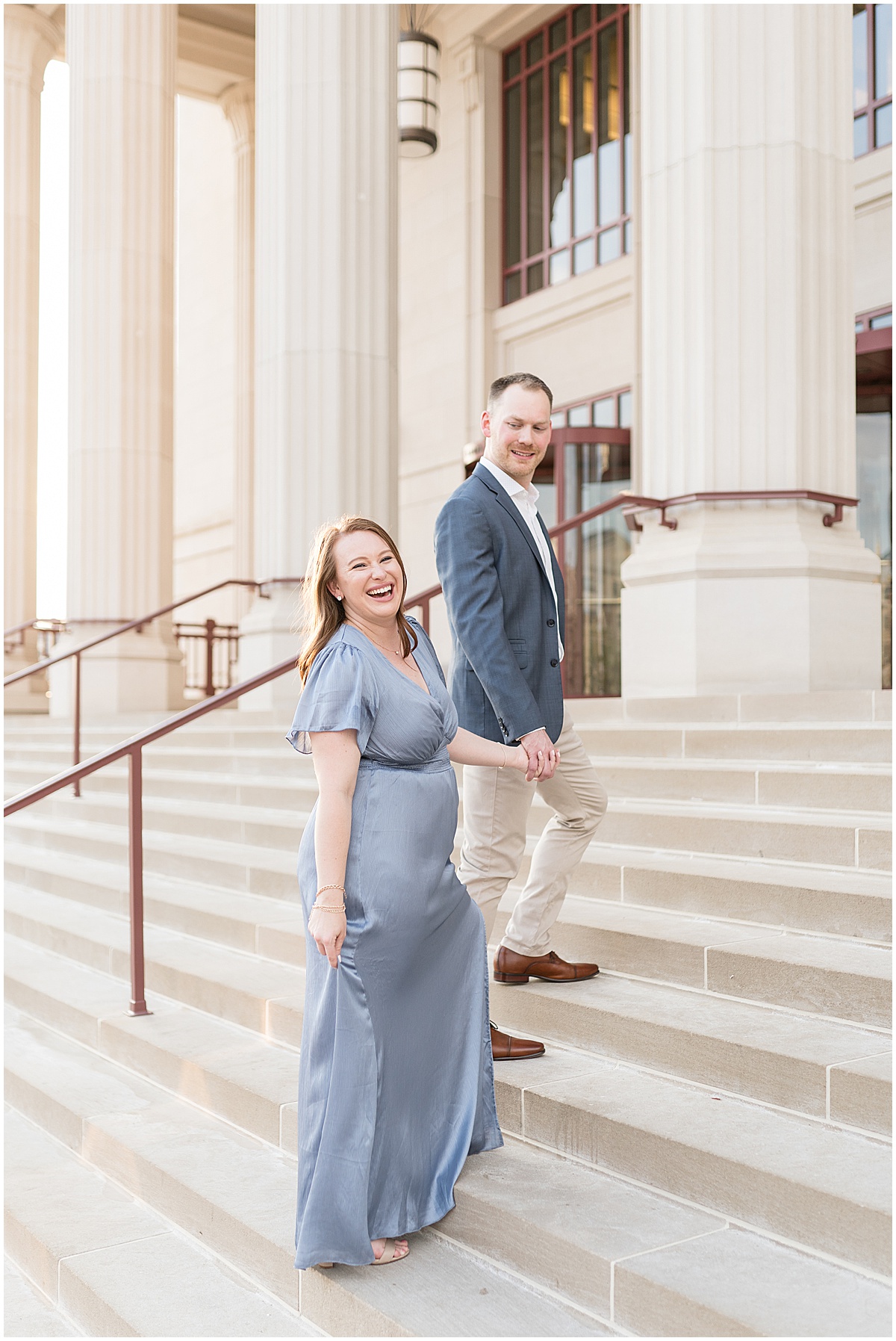 Couple walk up steps during engagement photos at The Palladium in Carmel, Indiana