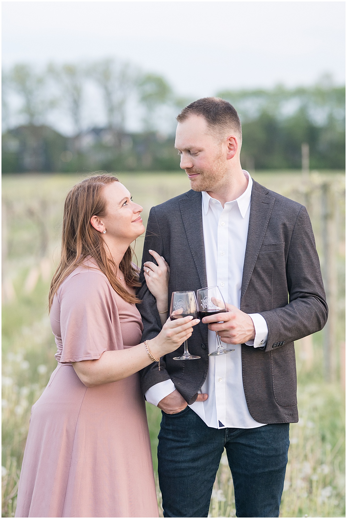 Couple drinking wine during engagement photos at Urban Vines in Carmel, Indiana