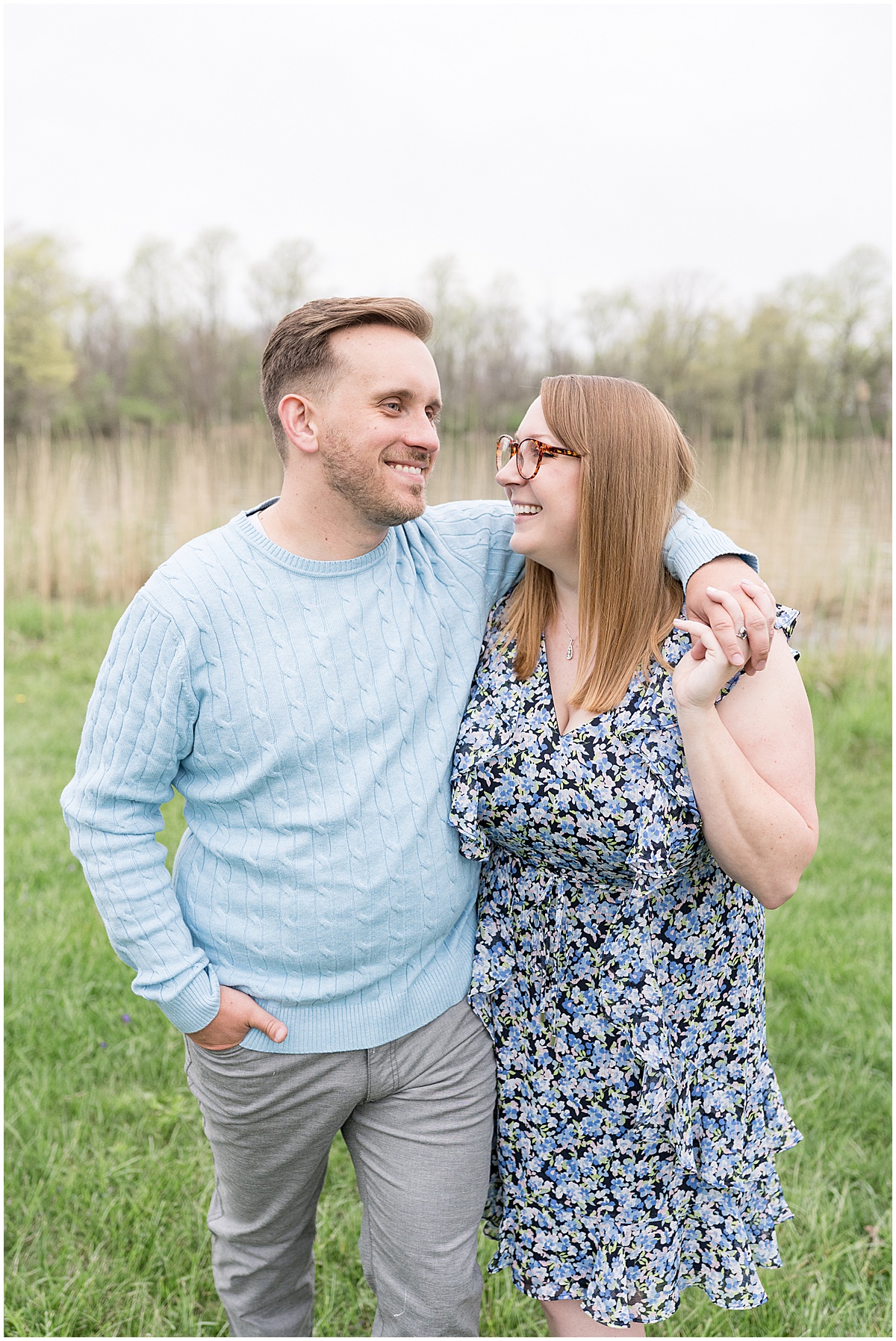 Couple laughing hand in hand during engagement photos at Wildcat Creek Reservoir Park in Kokomo, Indiana