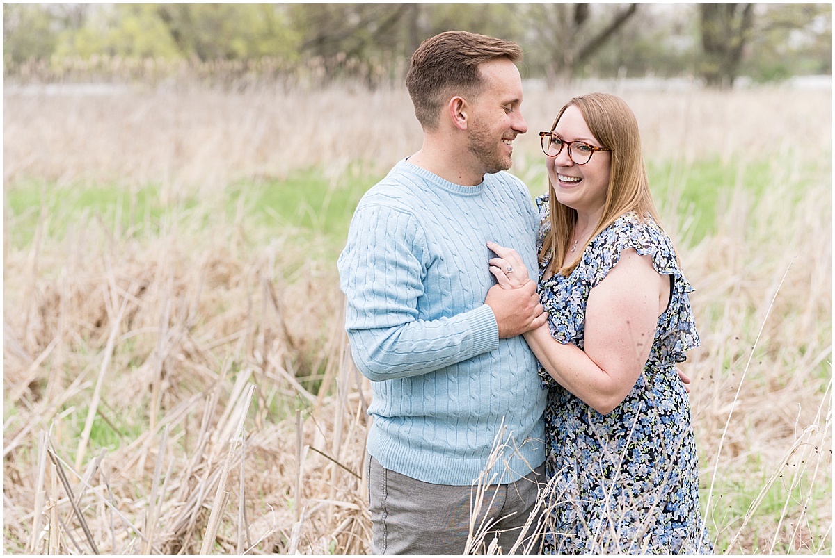 Couple laughing in field during engagement photos at Wildcat Creek Reservoir Park in Kokomo, Indiana