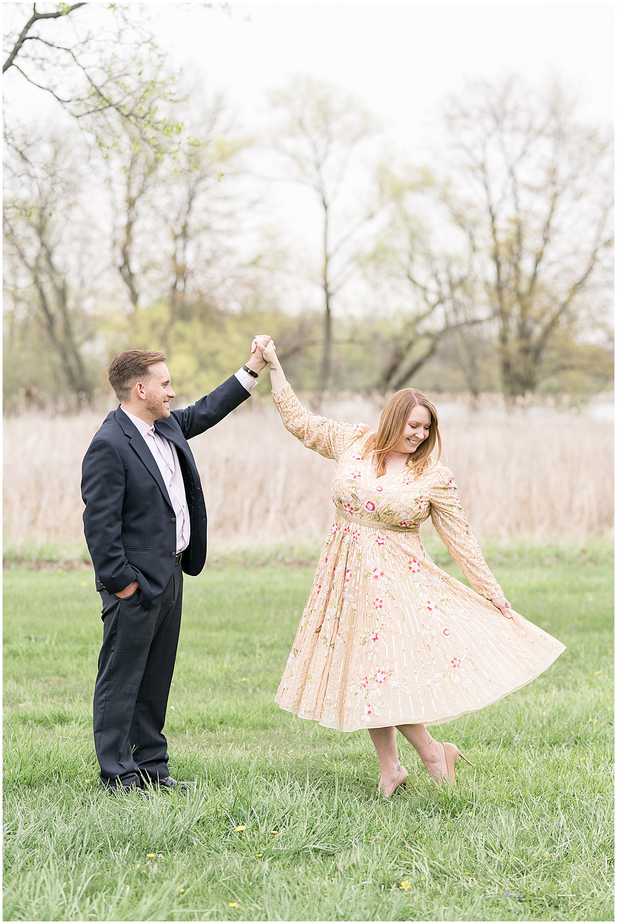 Couple twirling in field during engagement photos at Wildcat Creek Reservoir Park in Kokomo, Indiana
