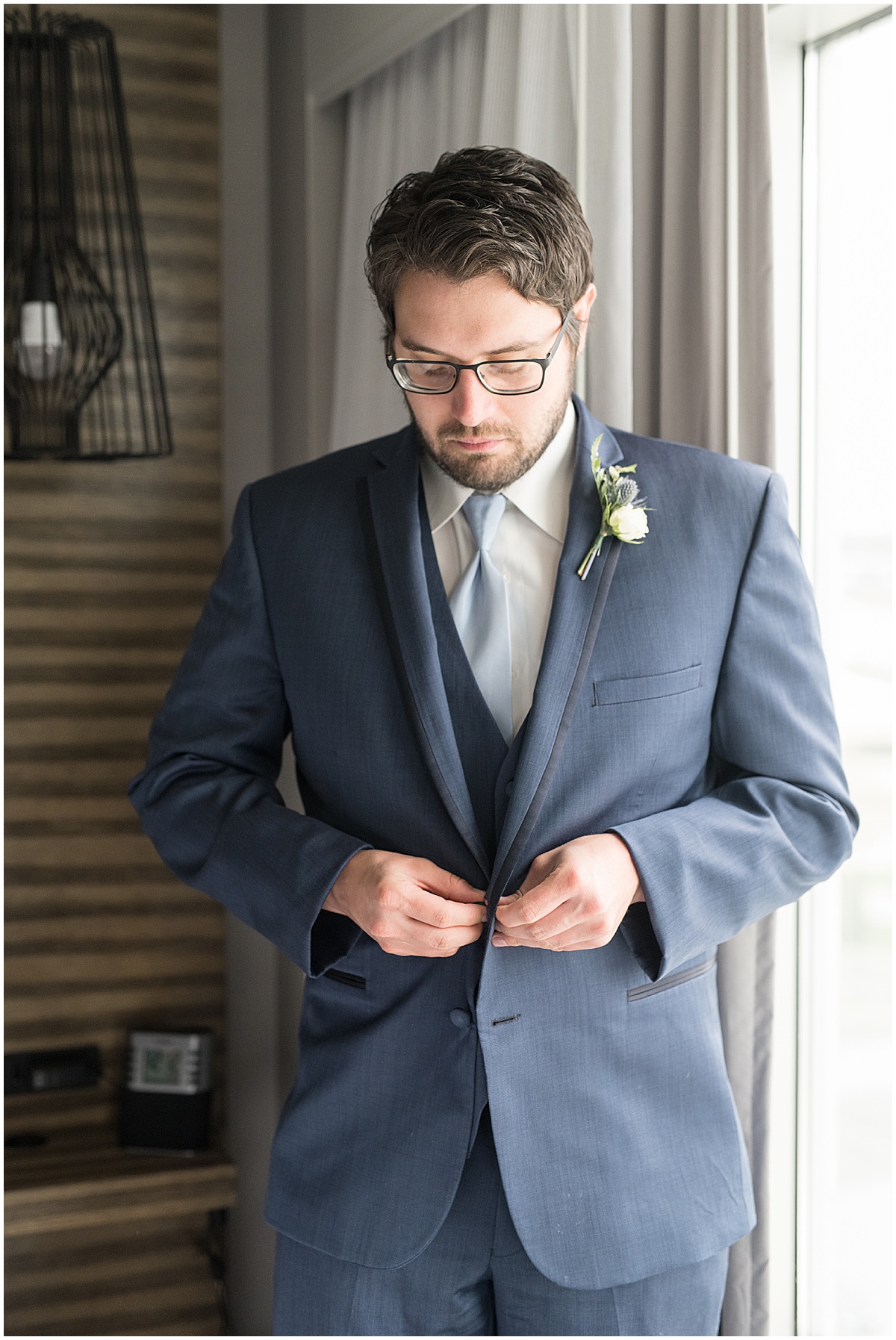 Groom buttoning jacket at Marriott North Indianapolis