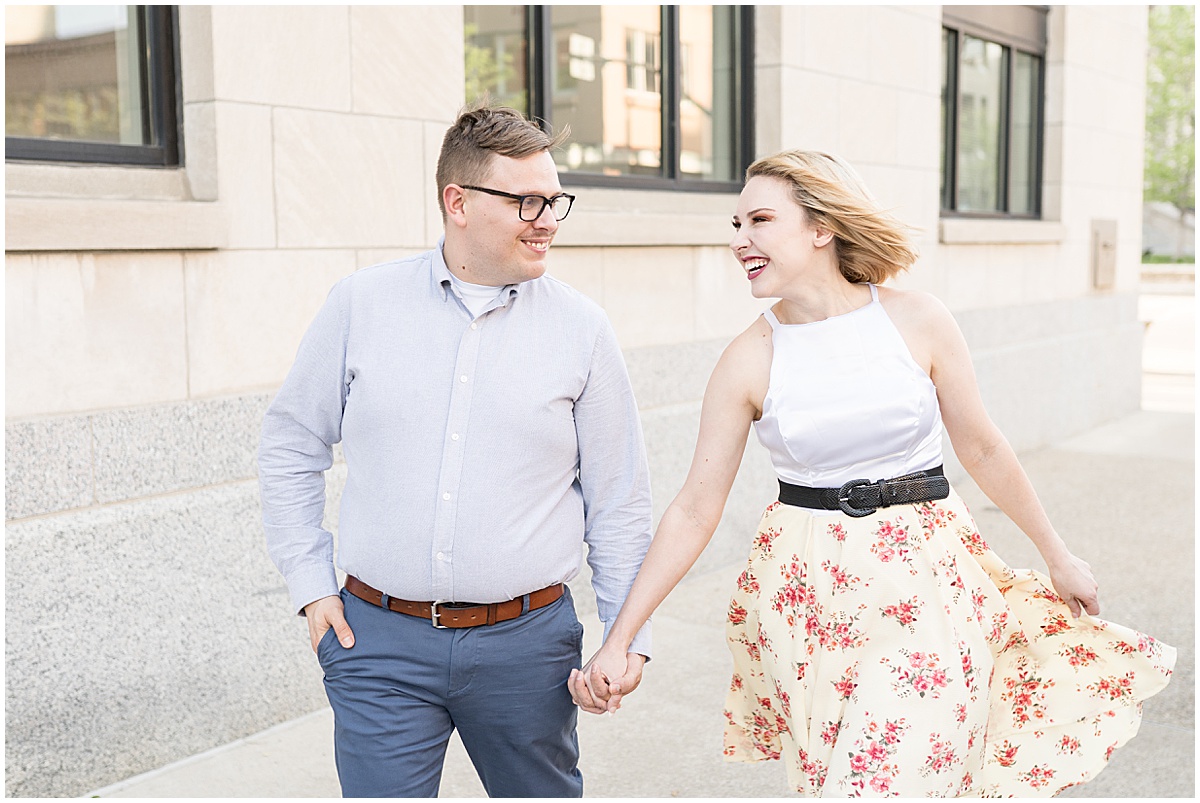Couple holding hands during spring engagement photos in Downtown Lafayette, Indiana