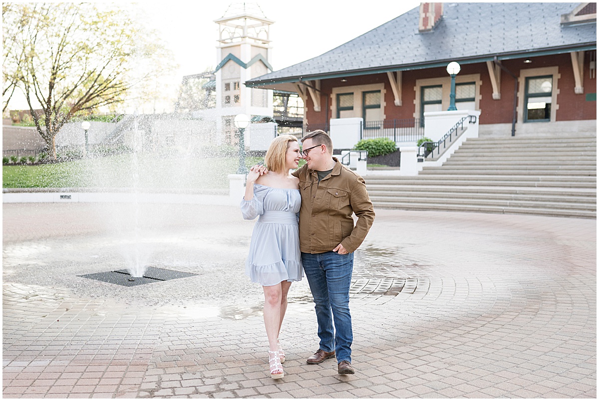 Couple kiss by fountain at spring engagement photos
