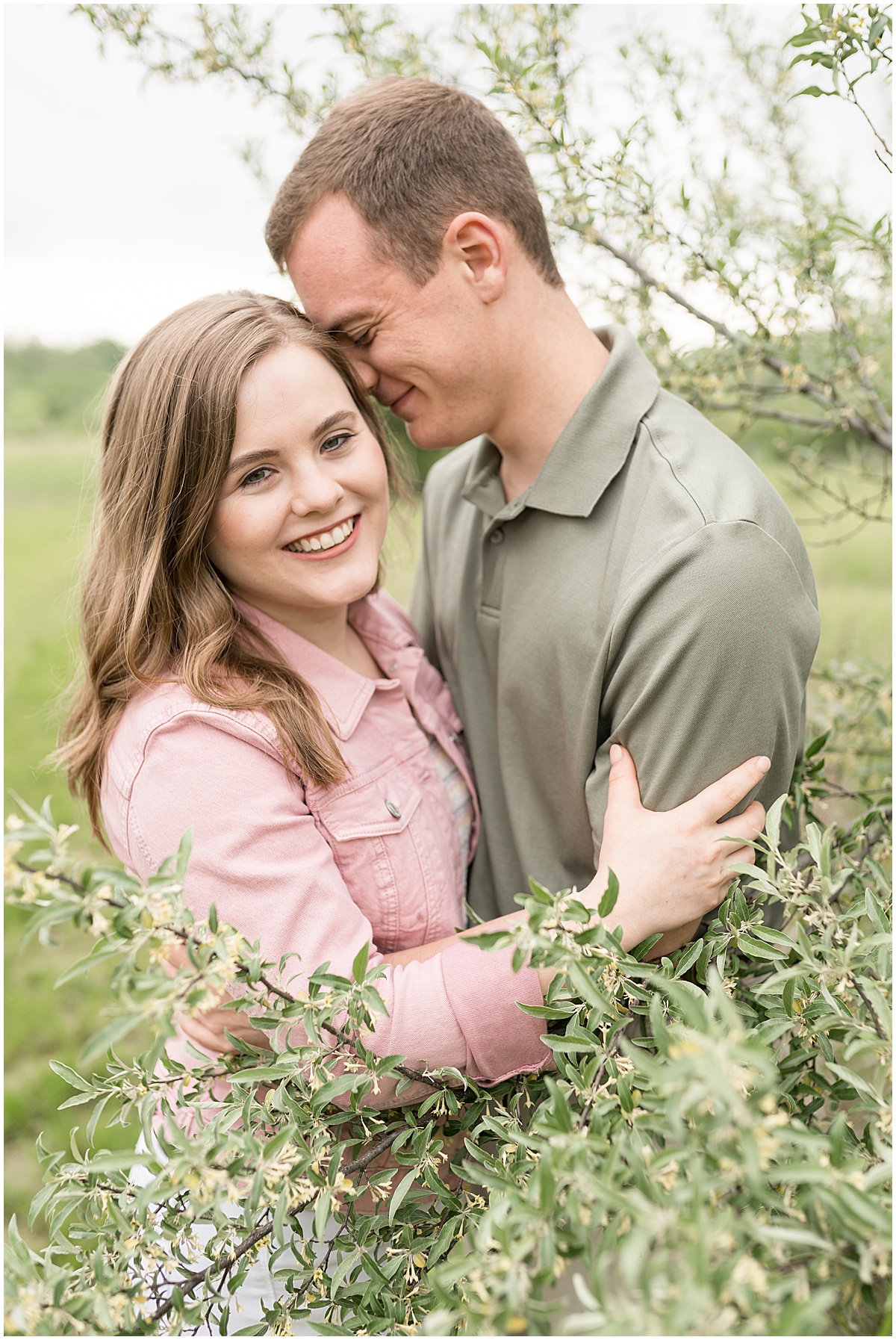 Couple hugging during engagement photos at Fairfield Lakes Park in Lafayette, Indiana