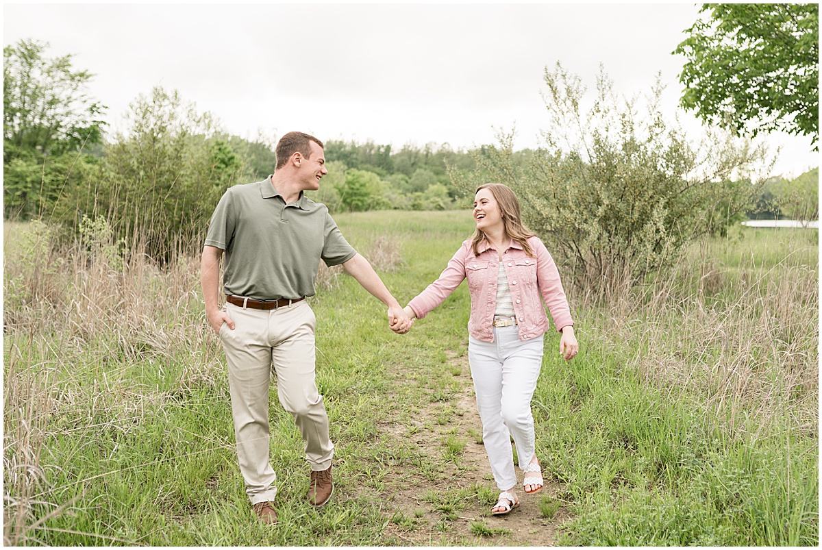 Couple walking on path during engagement photos at Fairfield Lakes Park in Lafayette, Indiana