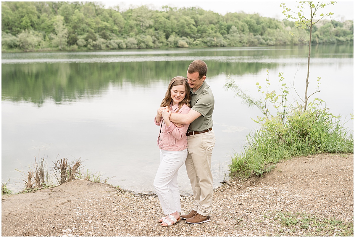 Couple by lake during engagement photos at Fairfield Lakes Park in Lafayette, Indiana