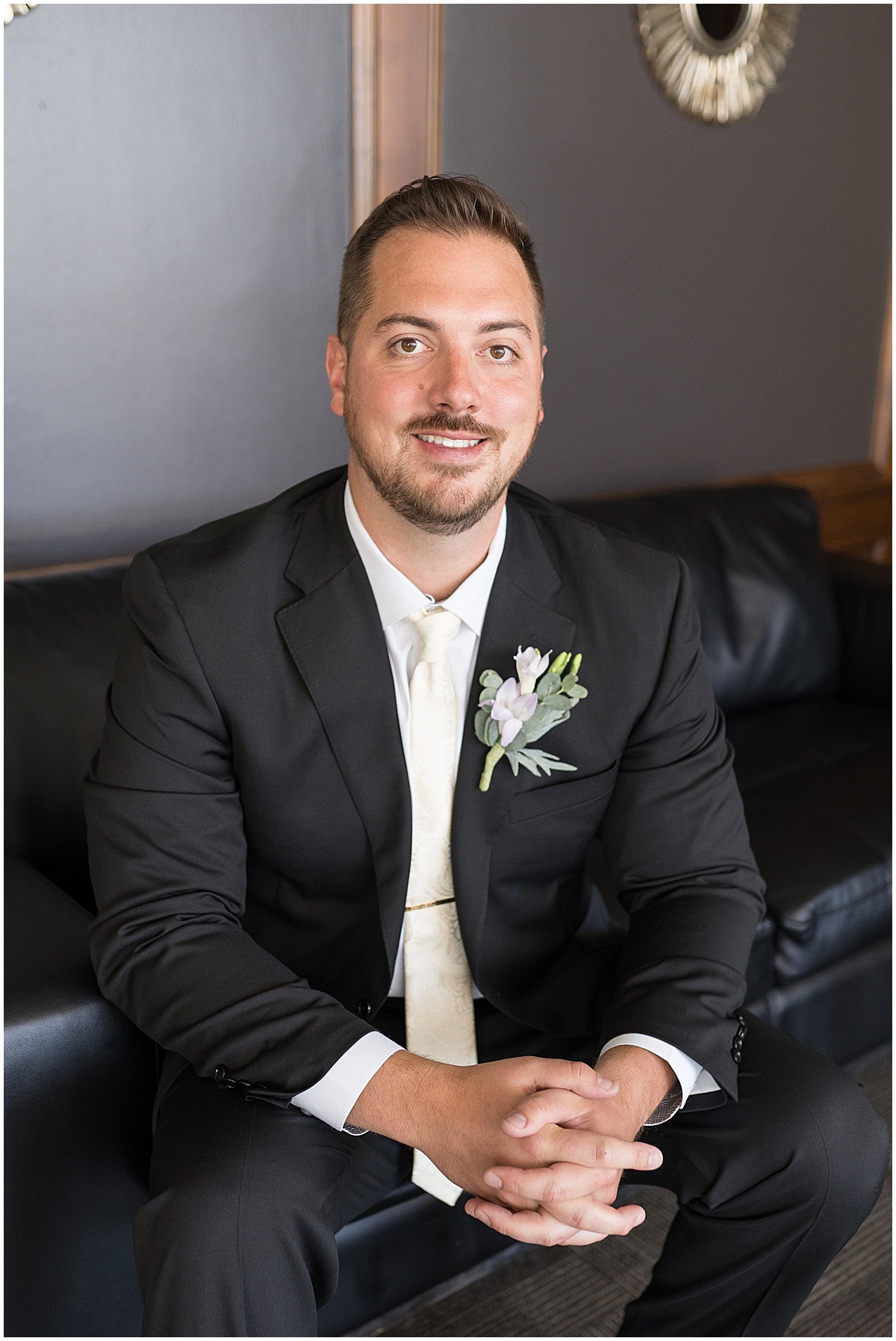 Groom portraits on couch before wedding at JPS Events in downtown Indianapolis.