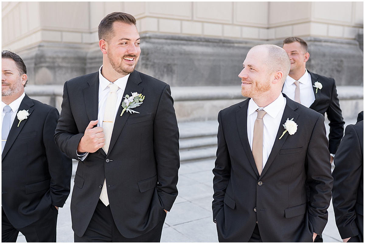 Groom walking with groomsmen at The Indiana War Memorial in downtown Indianapolis.