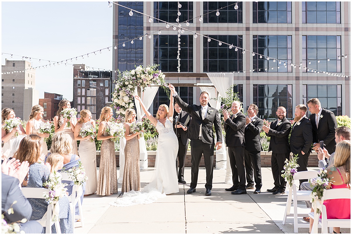 Bride and groom cheer at rooftop wedding in downtown Indianapolis at JPS Events