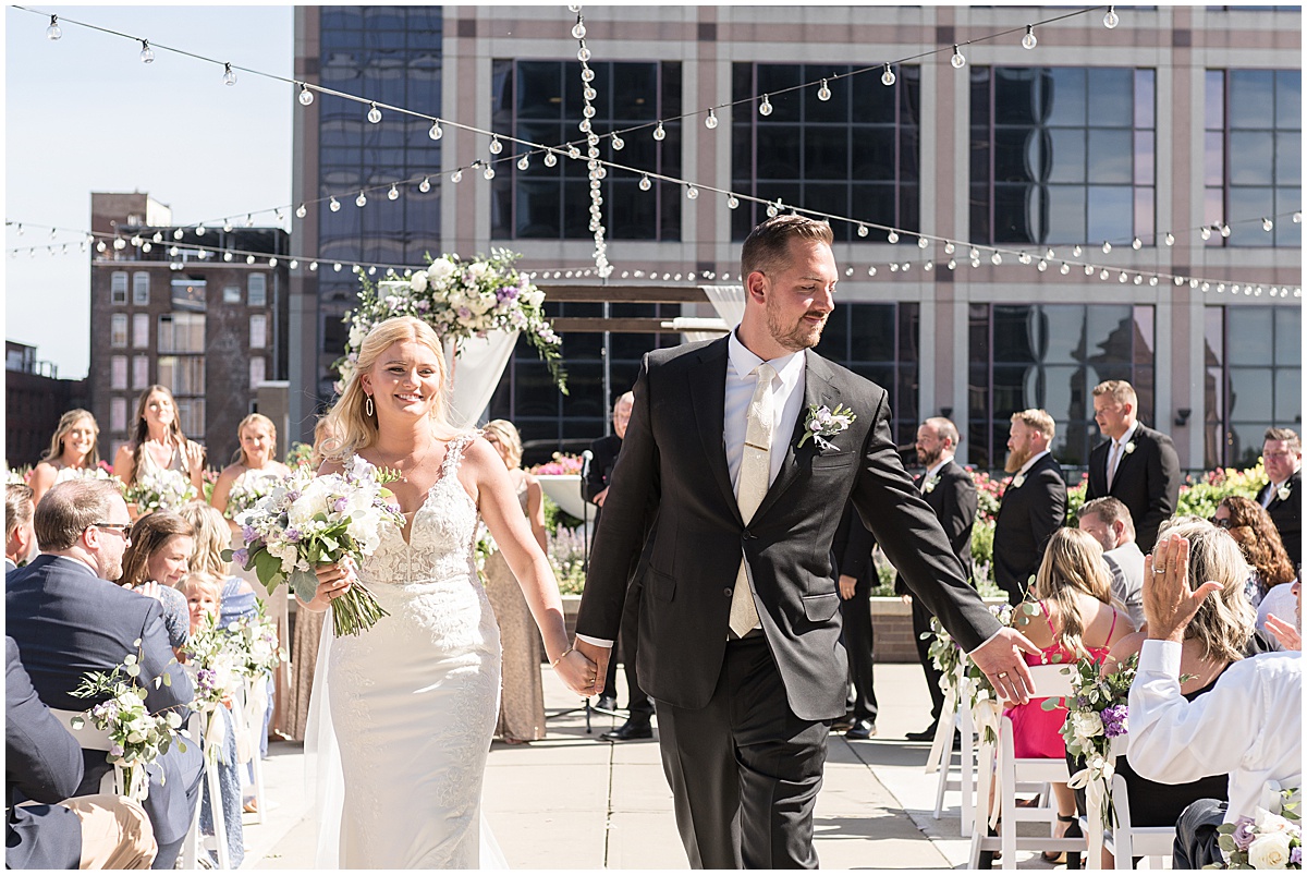 Bride and groom exit at rooftop wedding in downtown Indianapolis at JPS Events