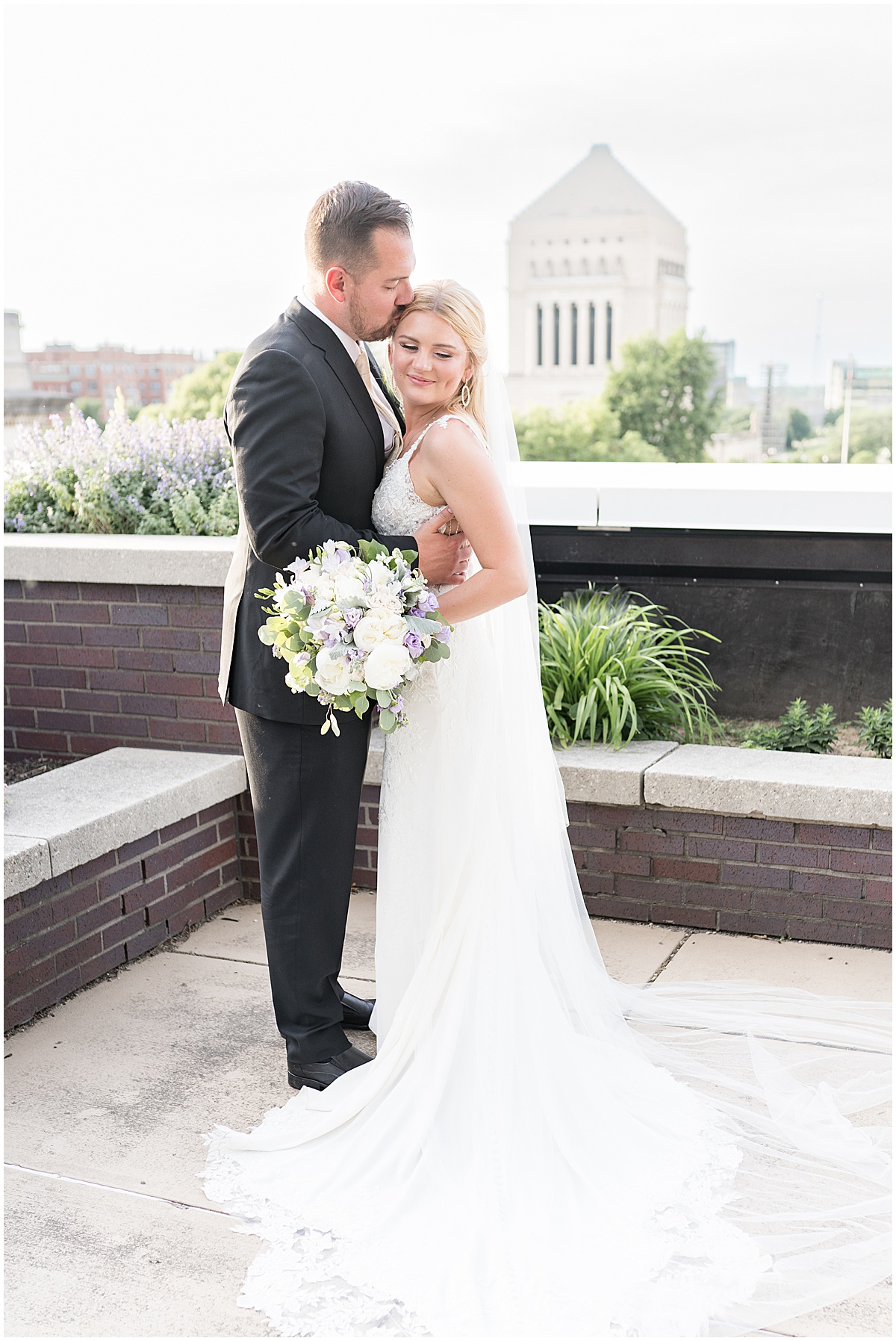 Groom kisses bride after rooftop wedding in downtown Indianapolis at JPS Events