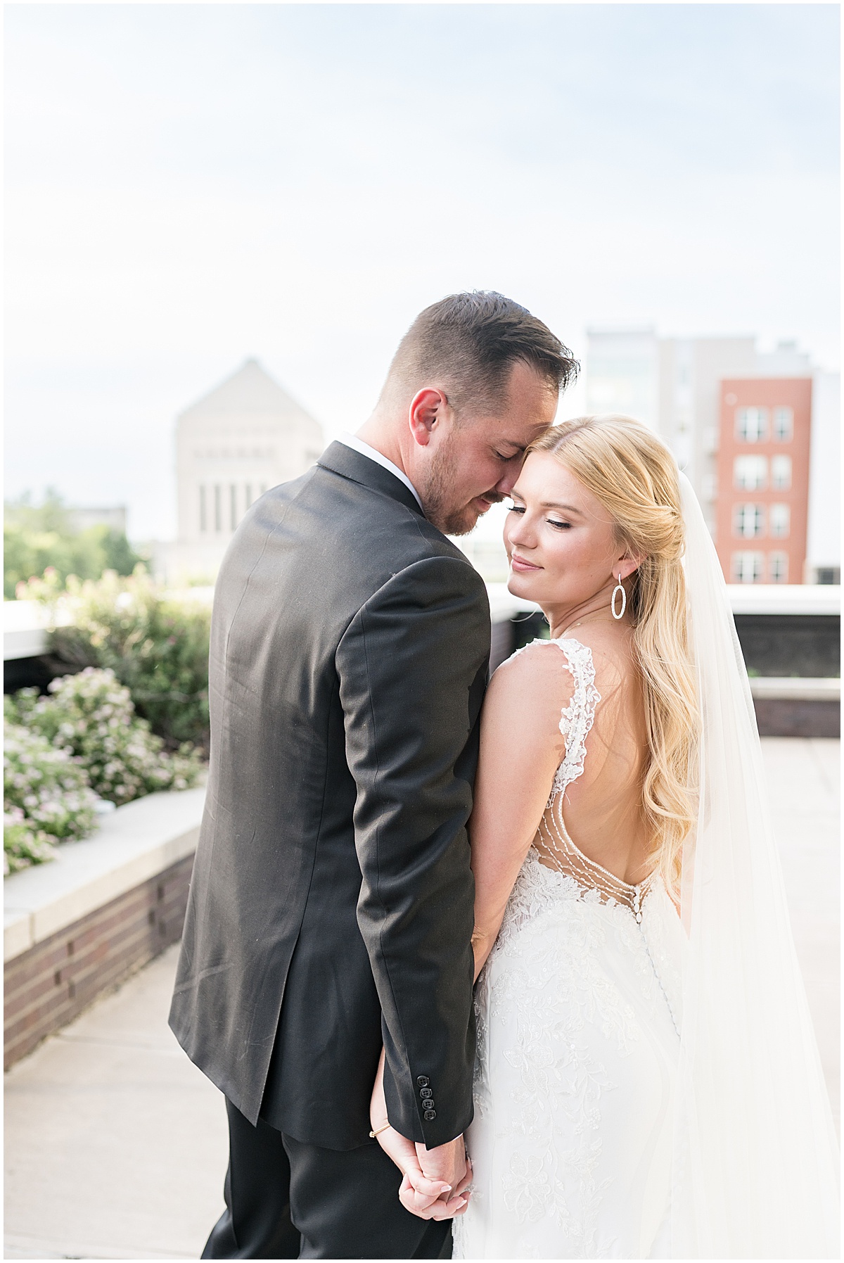 Bride and groom hold hands after rooftop wedding in downtown Indianapolis at JPS Events