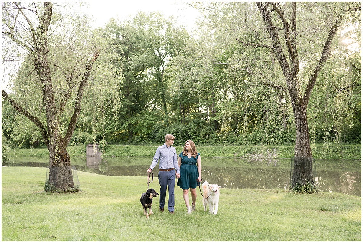 Couple walking dogs during spring engagement photos at Holcomb Gardens in Indianapolis