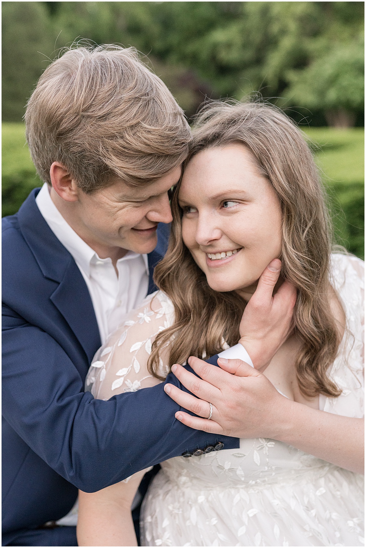 Couple holds each others face during spring engagement photos at Holcomb Gardens in Indianapolis