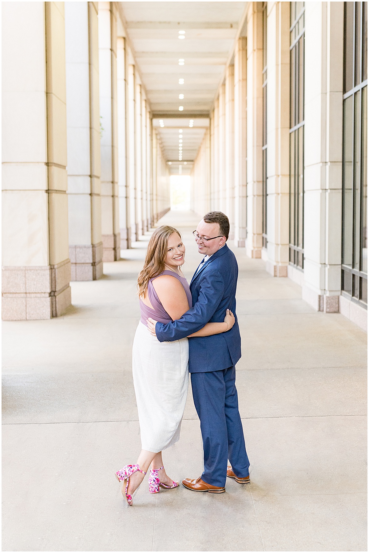 Couple walking together during engagement photos in downtown Indianapolis by the Indiana Government Center.