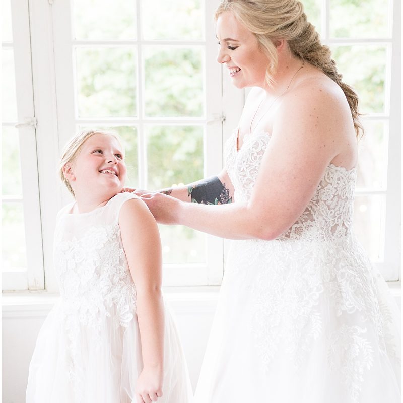 Bride helping flower girl get ready at Fowler House Mansion