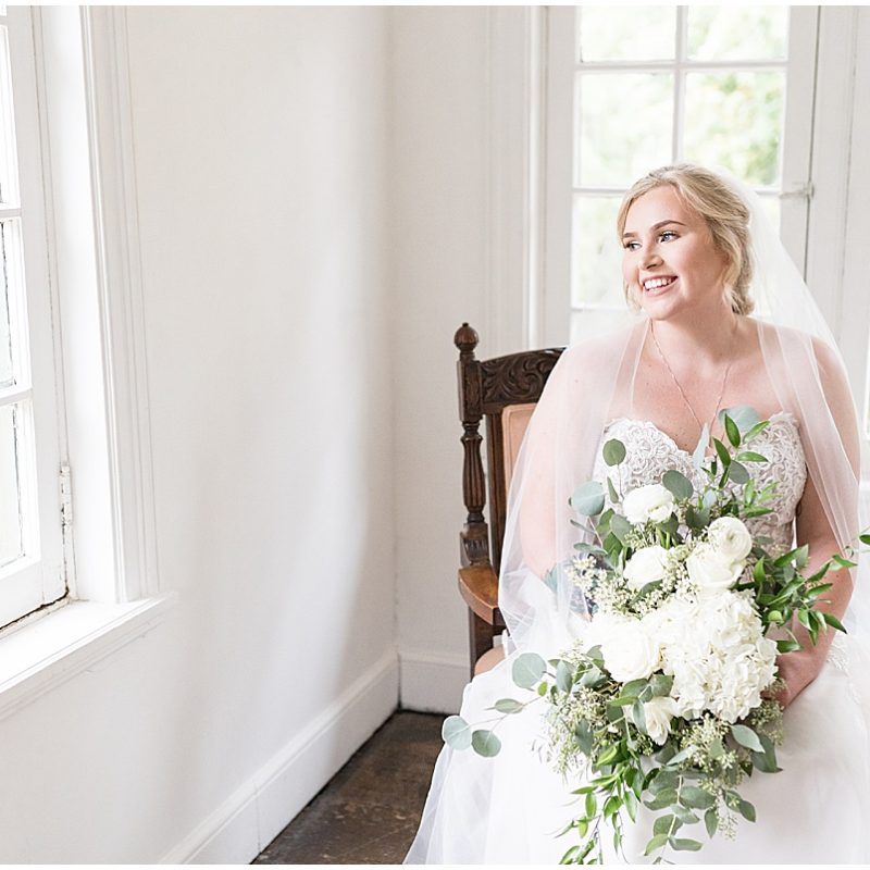 Bride looking out window at bridal suite in Fowler House Mansion