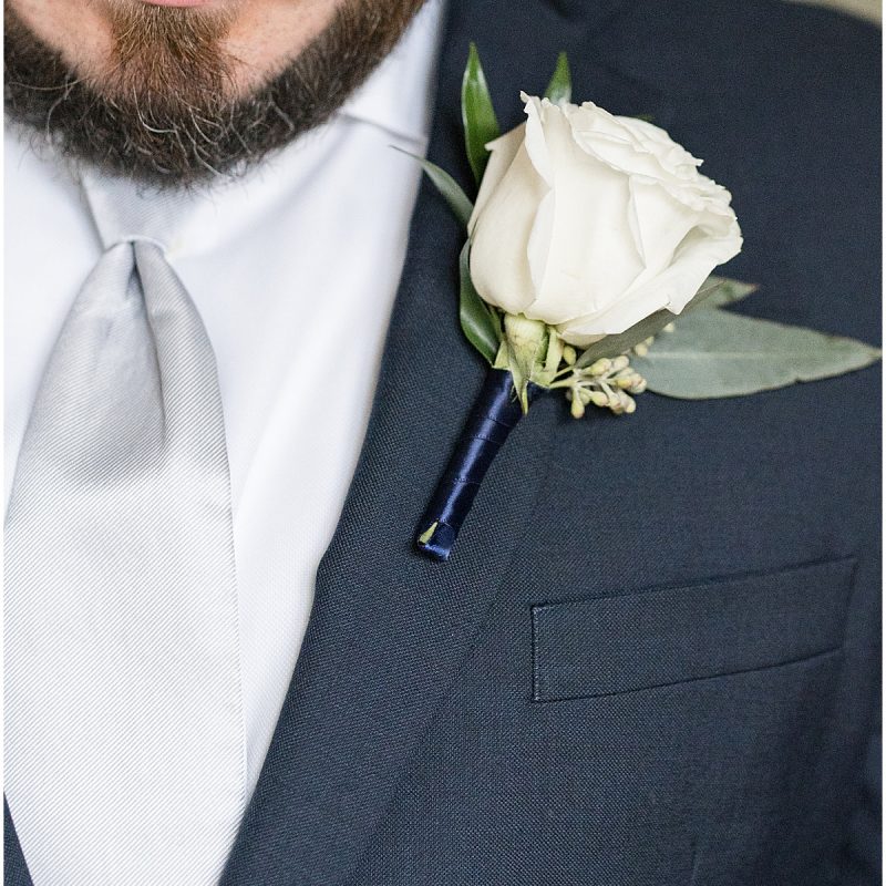 Close up of boutonnière on groom's jacket at Fowler House Mansion wedding