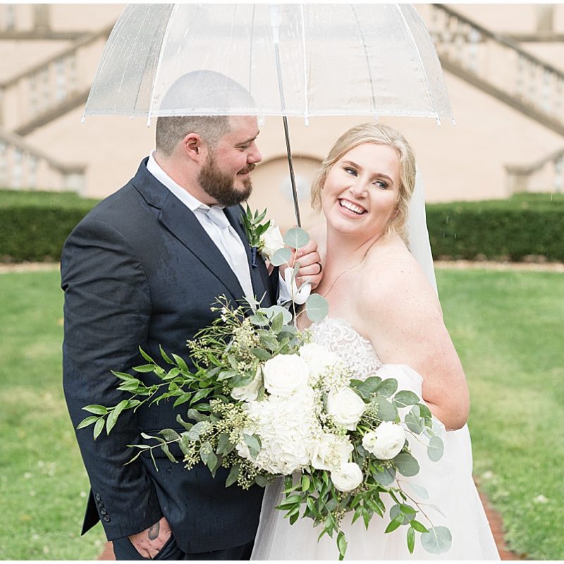 Bride and groom laughing under umbrella at Fowler House Mansion wedding