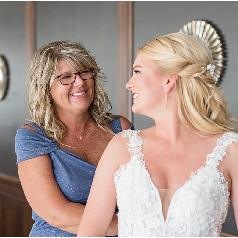 Bride having help buttoning up dress before JPS Events Wedding in Downtown Indianapolis