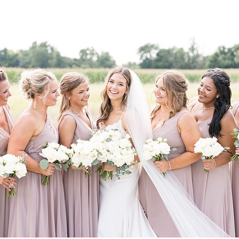 Bride and bridesmaids laugh before wedding at New Journey Farms