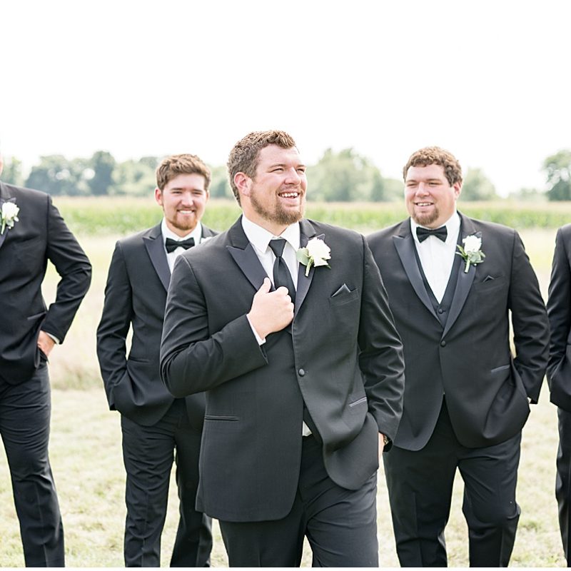 Groom and groomsmen laugh before wedding at New Journey Farms