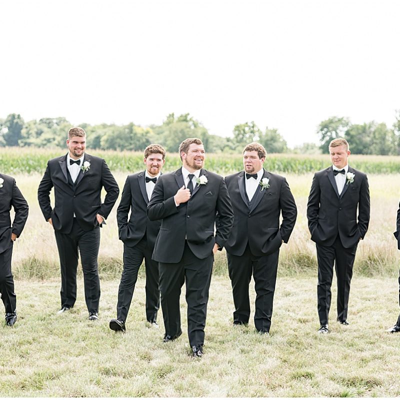Groom and groomsmen walk outside before wedding at New Journey Farms