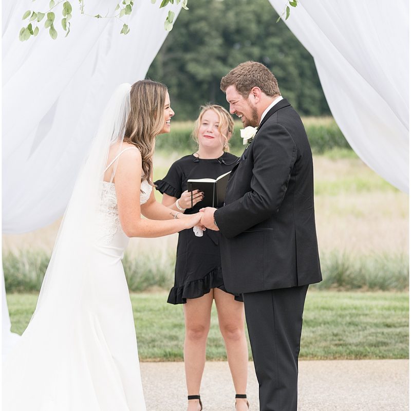 Bride and groom laugh during ceremony at New Journey Farms