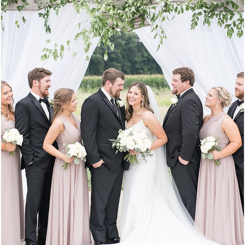 Bride laughs with bridal party after wedding at New Journey Farms