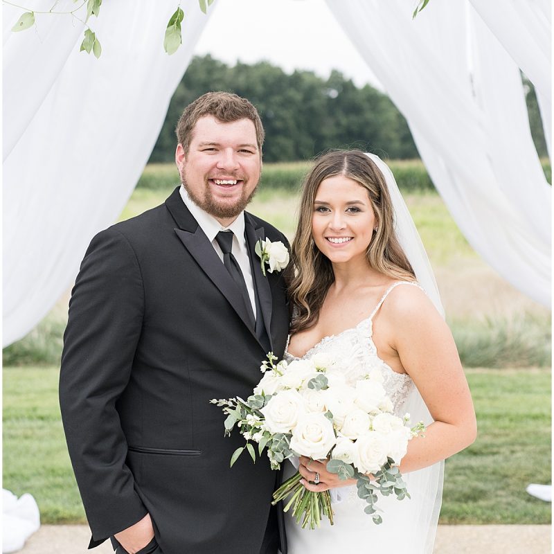 Bride and groom under ceremony arch at New Journey Farms