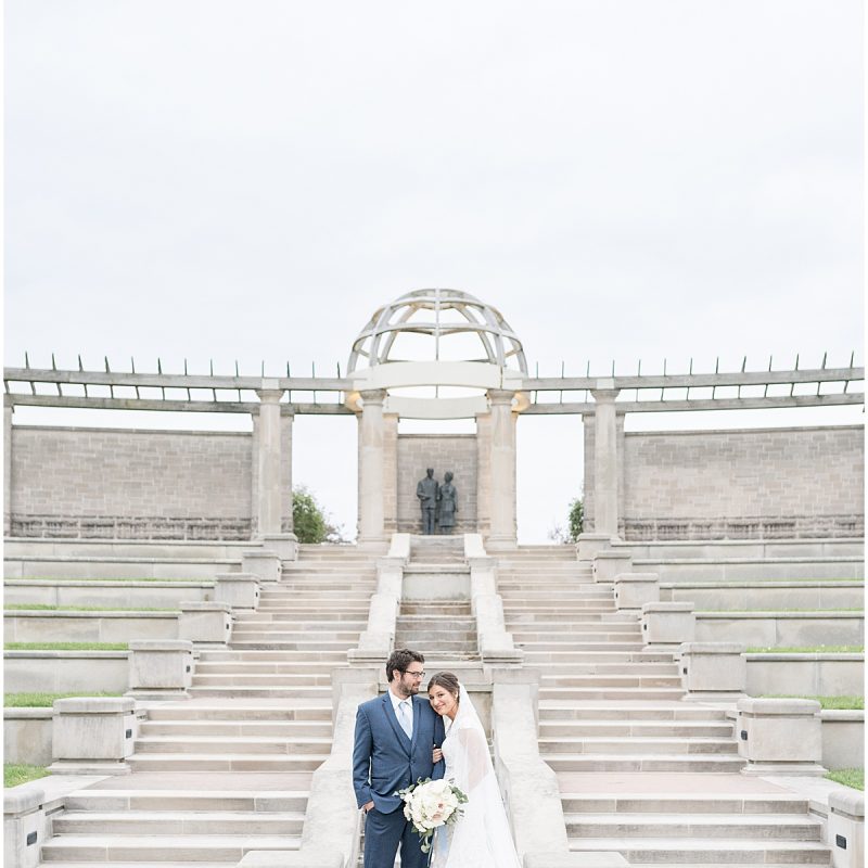 Bride and groom by steps during wedding photos at Coxhall Gardens