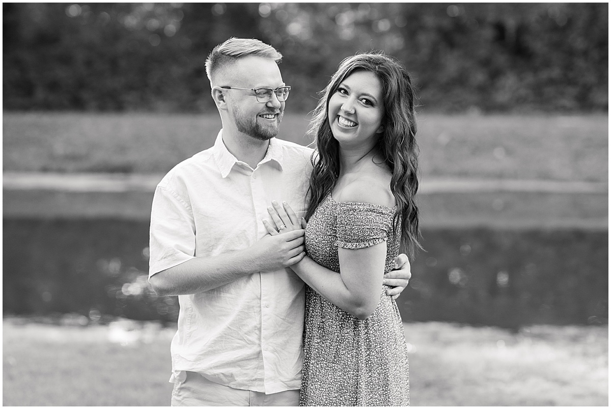 Couple standing by water during summer engagement photos at Holcomb Gardens in Indianapolis
