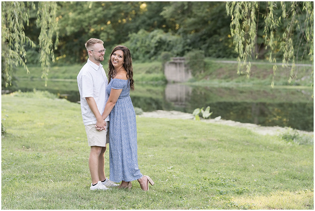 Couple holding hands during summer engagement photos at Holcomb Gardens in Indianapolis