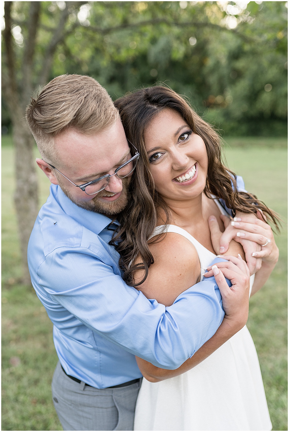 Couple hugging during summer engagement photos at Holcomb Gardens in Indianapolis