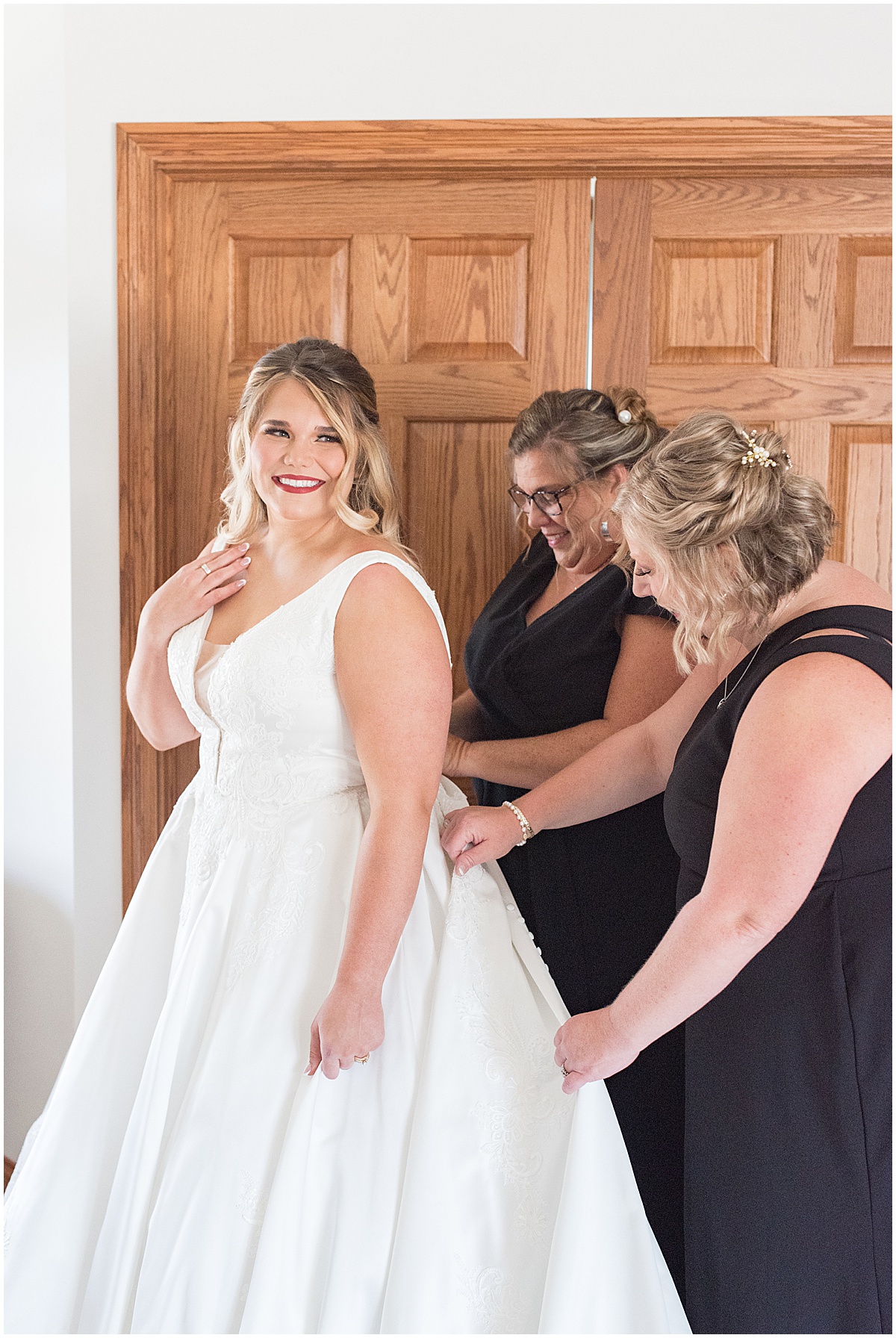 Bride having help getting ready for wedding in Converse, Indiana